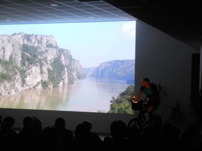 Olivier Bourguet à vélo sur scène présentant son film Eurovélo 6